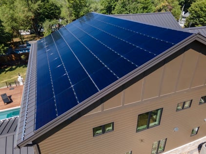 home with metal roof and snow retention and solar panels attached.