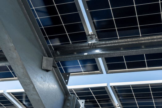 Underneath view of purlin-framed carport with solar panels attached.