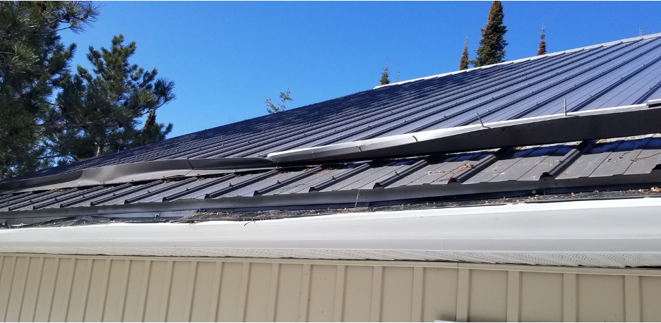 bent sheet metal used as snow guards on an exposed-fastened metal roof